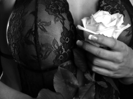 Erotikportrait einer Frau in Spitzenunterwäsche mit Rose in der Hand